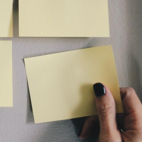 Hand grabbing sticky note